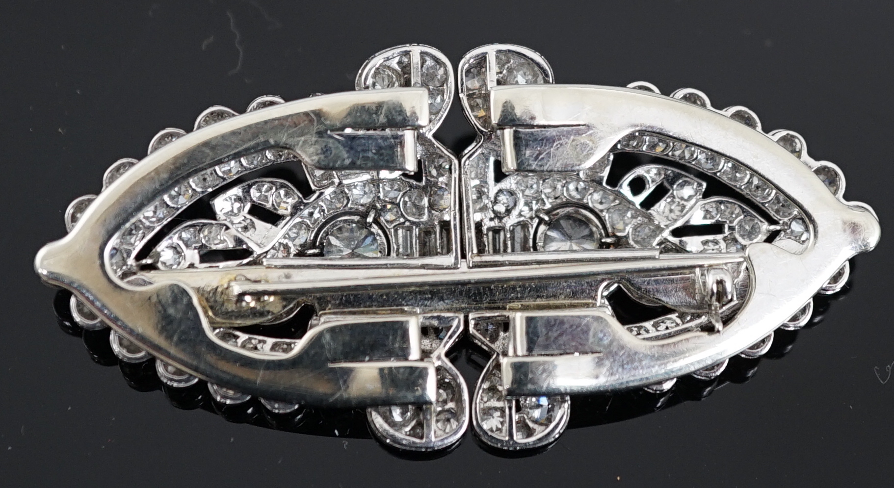 An Art Deco white gold, round and baguette cut diamond set double clip brooch